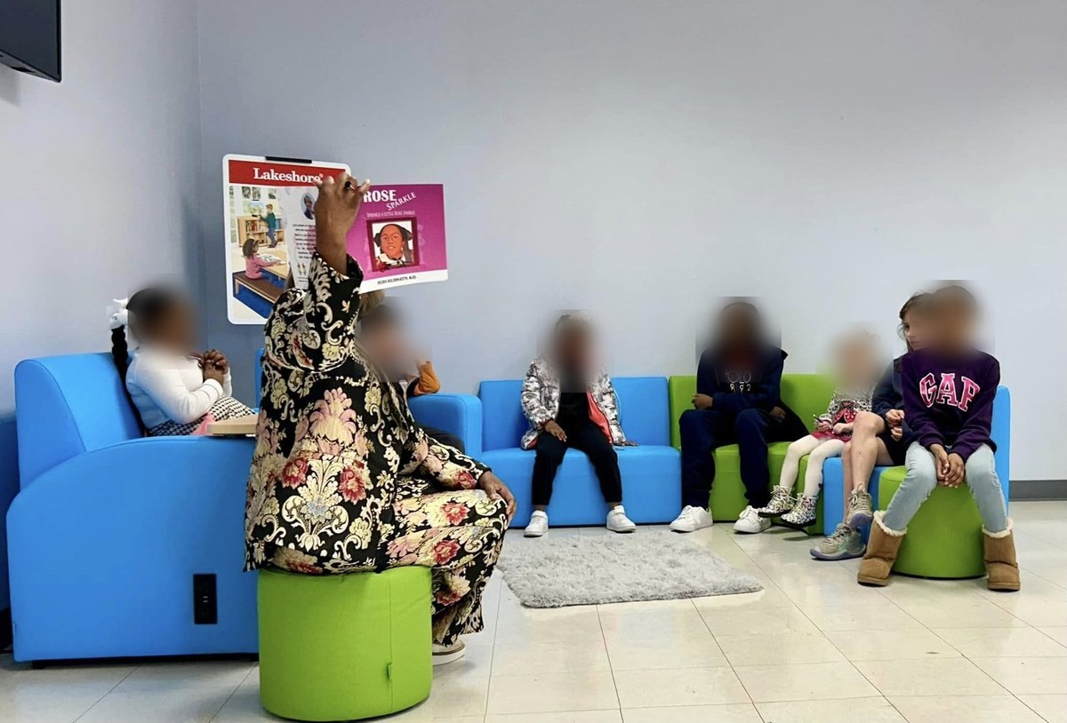 Desira leading an interactive read-aloud with a group of young children